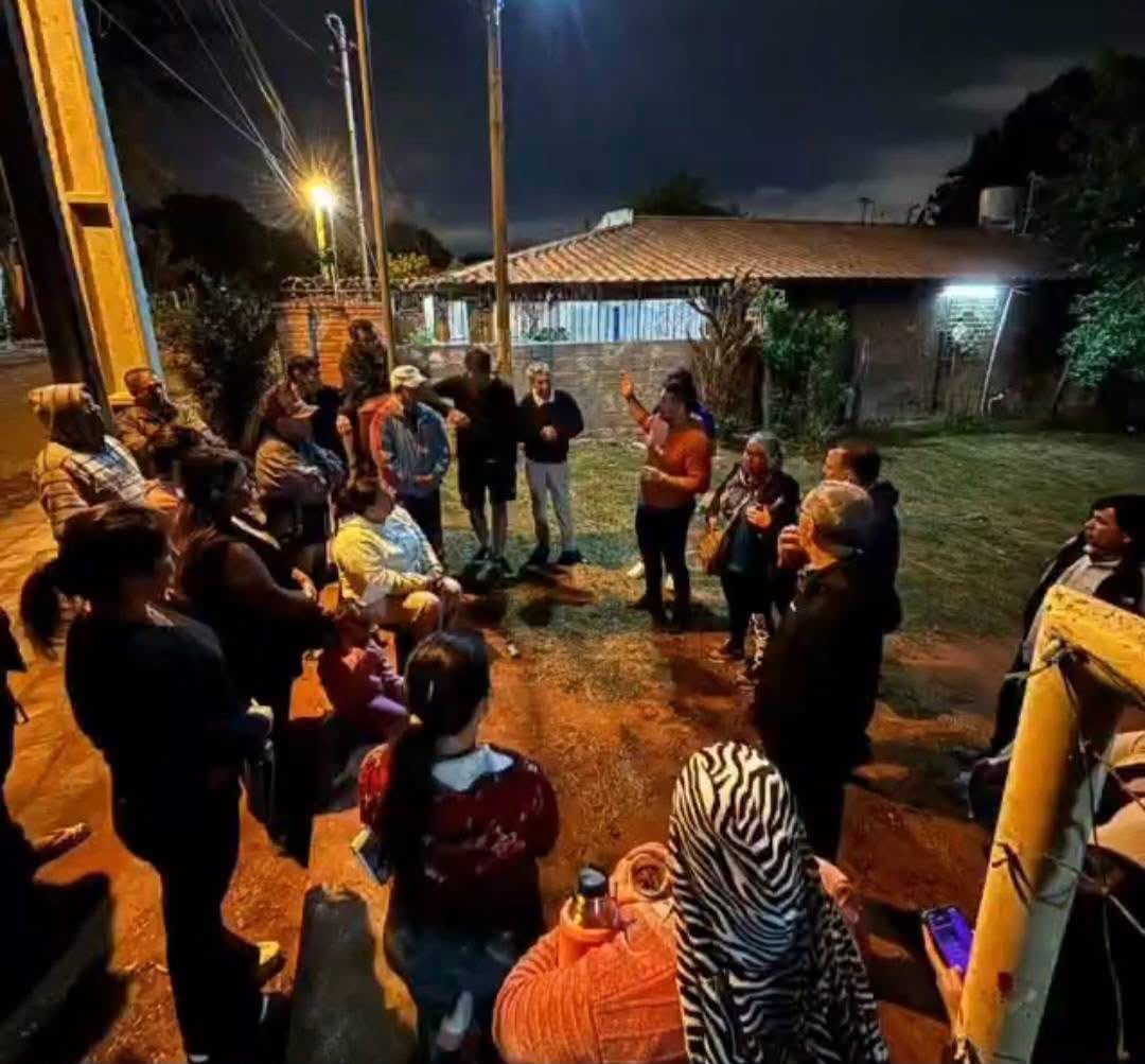 Vecinos de Ñemby reunidos de noche en la calle de su barrio